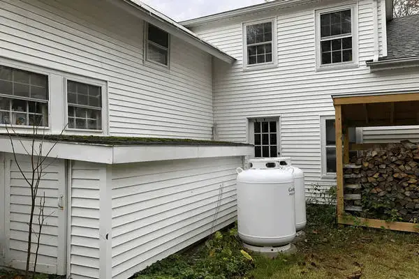 Green mold removed from white vinyl siding After house washing service.